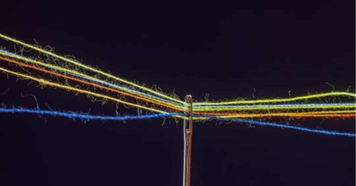 Multiple colored threads through the eye of a needle 